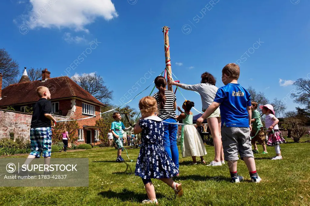 Kids dancing round maypole; Great Chart, Kent, England, UK
