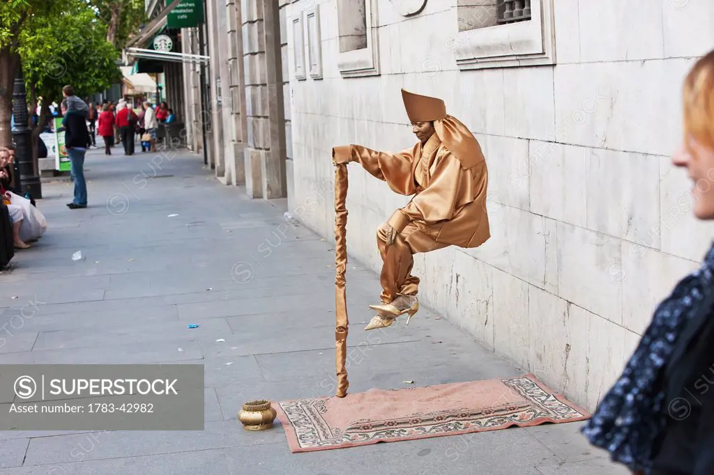Street artist performing trick during April Feria Festival; Seville, Andalucia, Spain, Europe