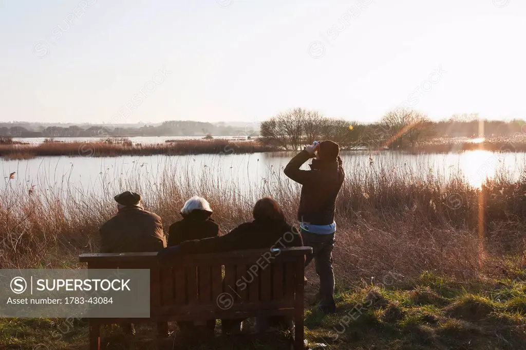 Bird watchers at sundown at Shapwick Heath, wetland reserve of Avalon Marshes of Somerset Levels; Somerset, England, UK