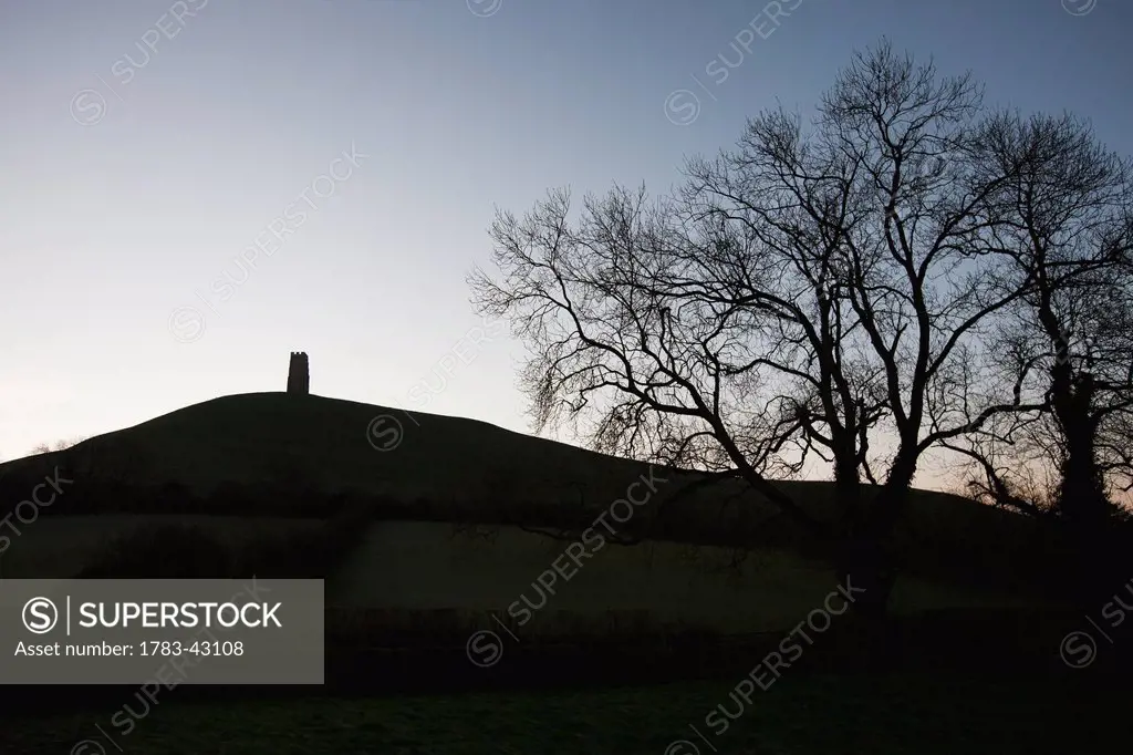 Silhouette of hill and tower; Glastonbury, Somerset, England, UK