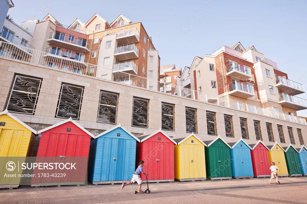 Colorful beach huts and modern apartments at Honeycombe Beach next to Boscombe Pier in Boscombe; Bournemouth, Dorset, England, UK