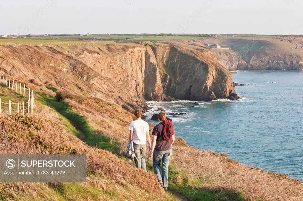 Two young men hiking, St. Non's Bay, Pembrokeshire Coastal Path; Wales, United Kingdom