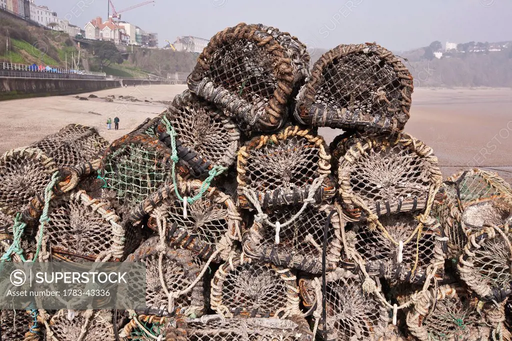 Lobster pots at harbor with North Beach in background; Tenby, Pembrokeshire Coast Path, Wales, United Kingdom