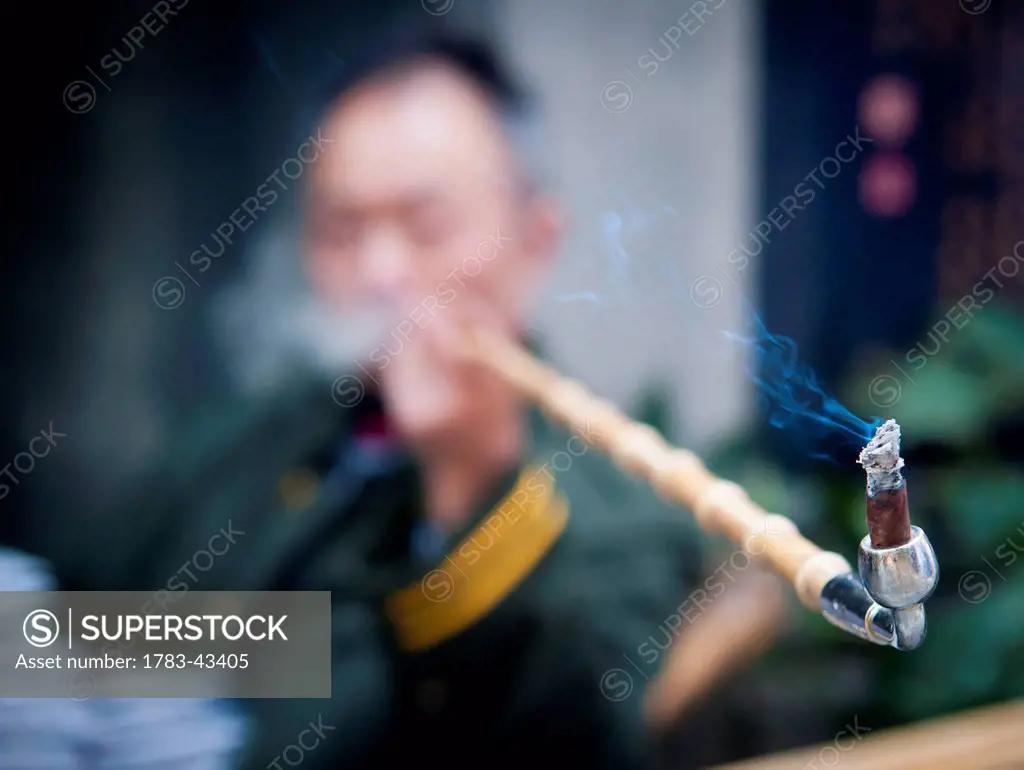 Man smoking pipe; China