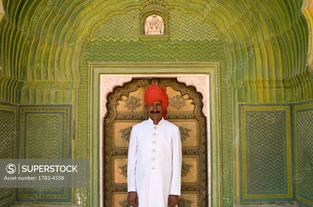 Palace guard in decorated entrance area of small door of the City Palace, Jaipur, Rajasthan, India