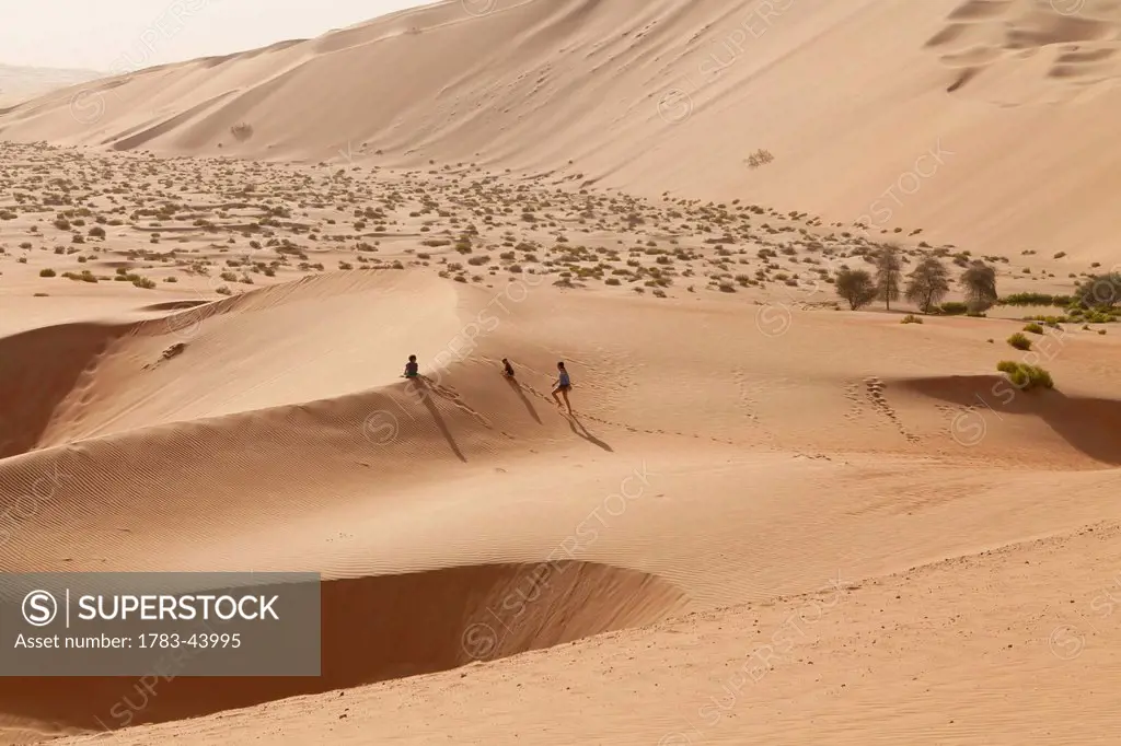 A family walking in the Empty Quarter; Liwa Oasis, Abu Dhabi, United Arab Emirates