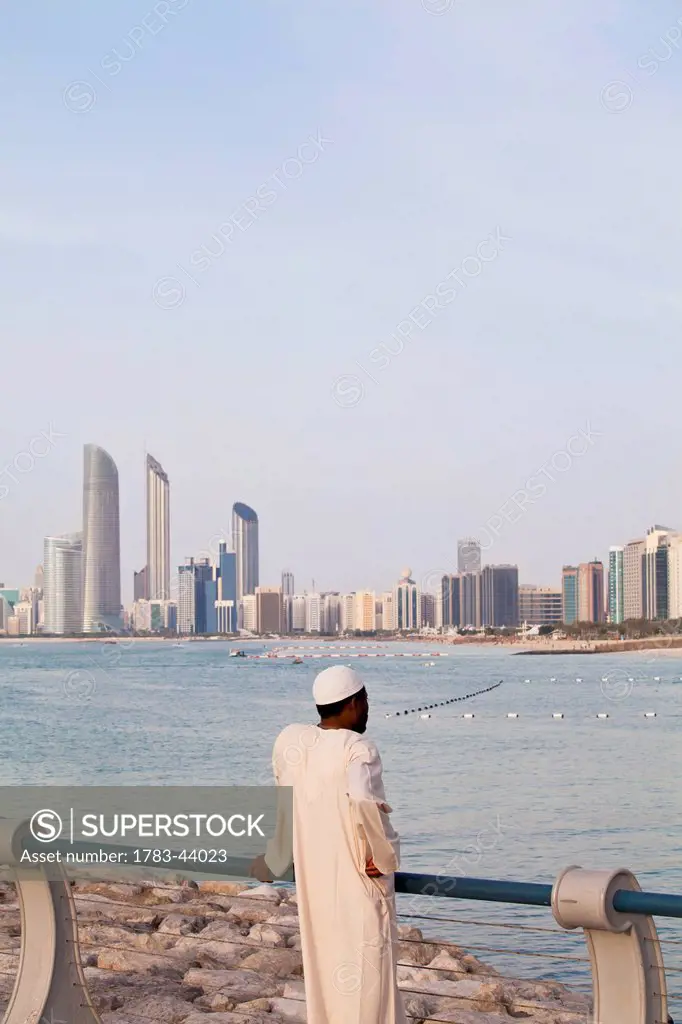 Local UAE man looking at Abu Dhabi cityscape; Abu Dhabi, United Arab Emirates