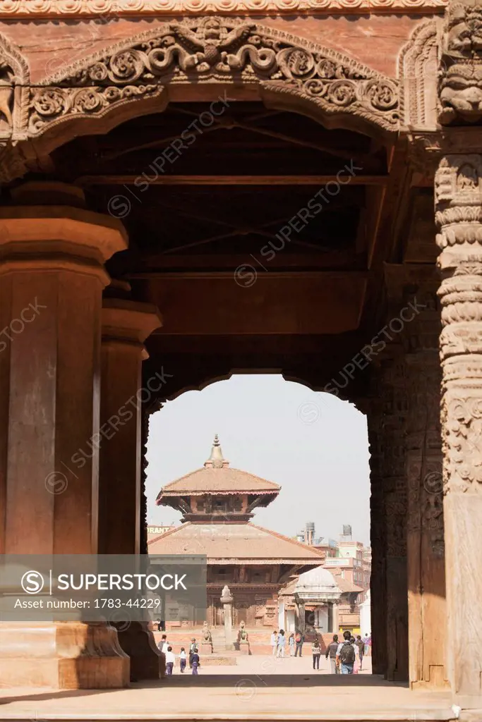 A view through collosal carved arches towards the Gopi Nath Temple in Bhaktapur Durbar Square; Bhaktapur, Nepal