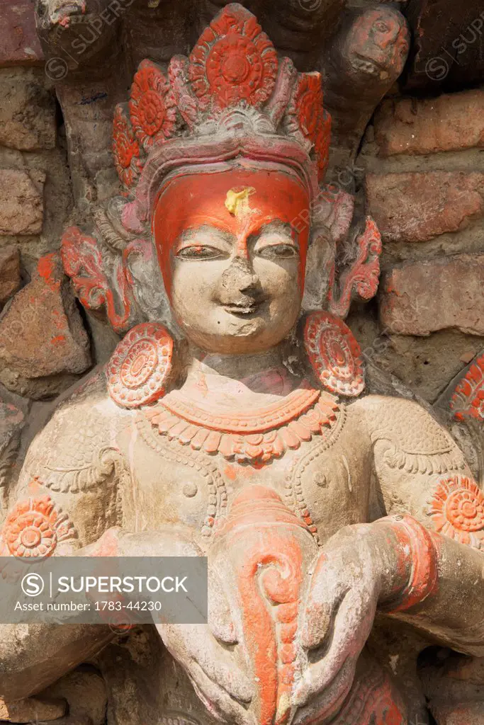 Carving of Narayan (Vishnu) holds a conch on the wall of a small temple; Bhaktapur, Nepal