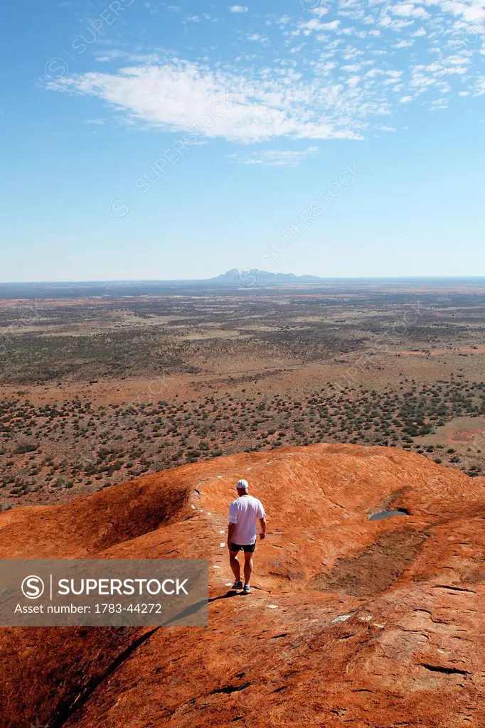 Tourists walking up Uluru, formerly known as Ayers Rock; Northern Territory, Australia