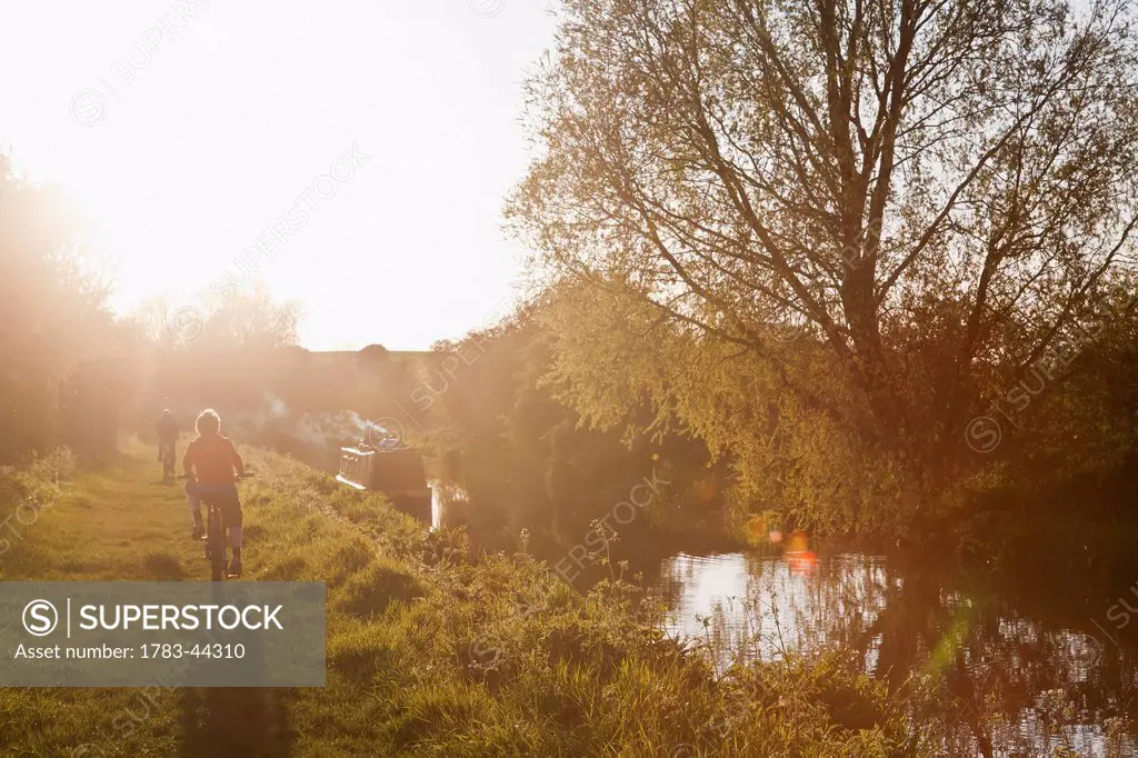 Cycling along Kennet and Avon Canal at sunset; Wiltshire, England