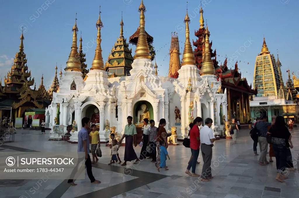 Visitors walk around Shwedagon Pagoda at sunset; Yangon, Burma