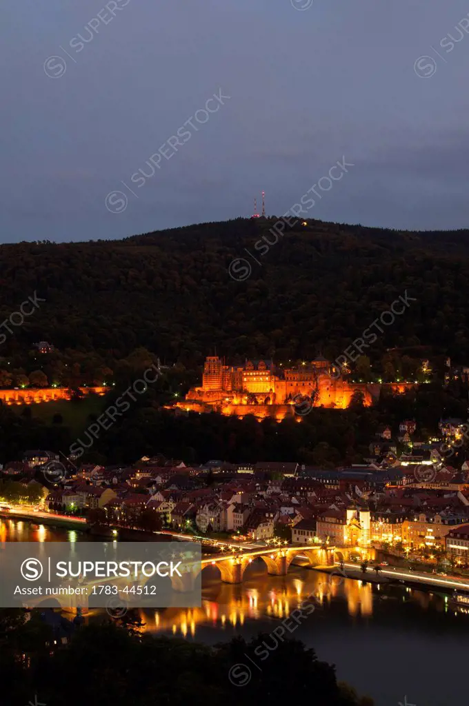 Heidelberg Castle and the old bridge over River Neckar illuminated at nighttime; Heidelberg, Germany