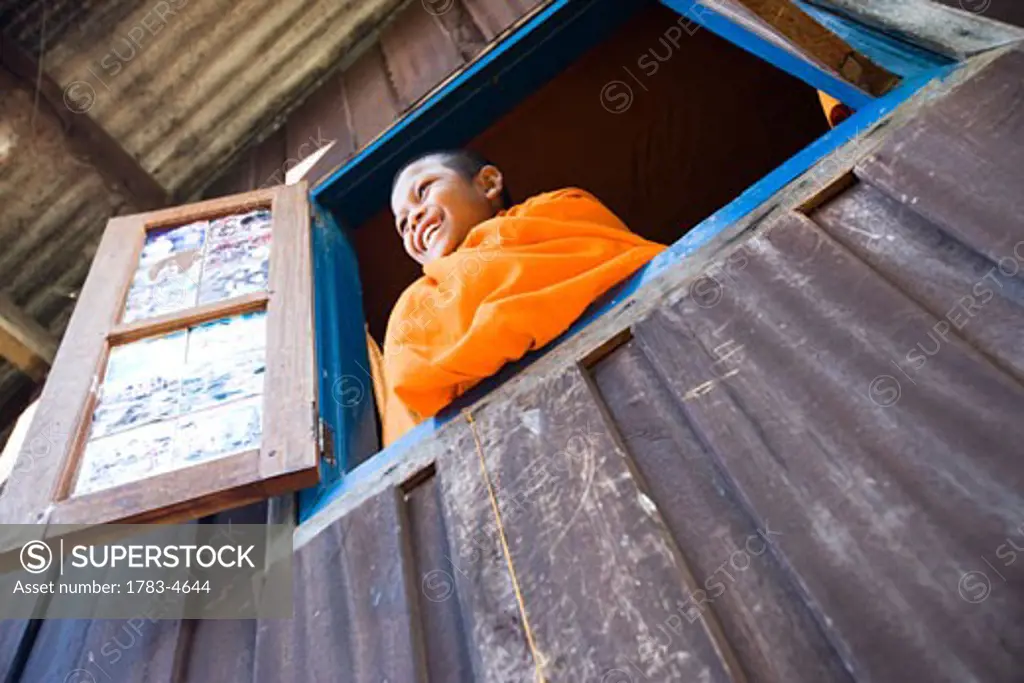Novice monk looking out of window at Vang Vieng, Laos
