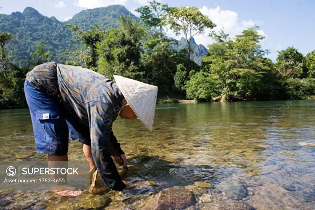 A local woman standing in a river, Vang Vieng, Laos
