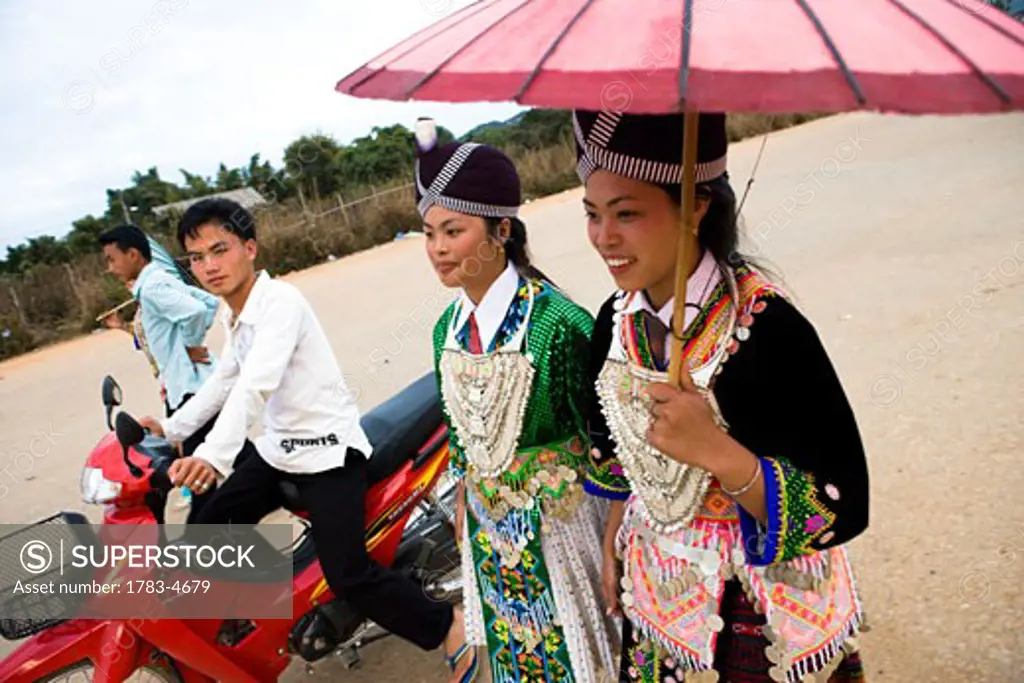 Hmong girls in traditional costume being courted by boys at the New Year festival, Phonsavan, Laos