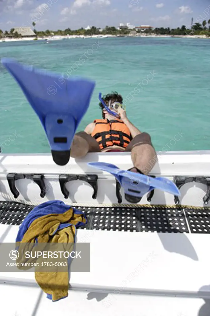 Man wearing snorkel gear jumping boat on Mayan Riviera, Yucatan Peninsular,Quintana Roo State,Mexico
