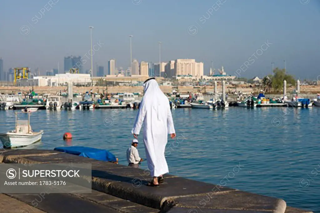 Man in traditional gown and Doha bay skyline, Doha,Qatar
