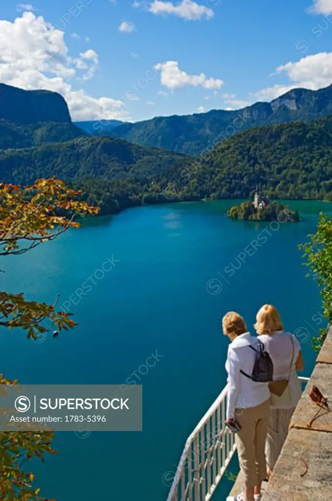 Two tourists looking at Lake Bled from castle terrace, 