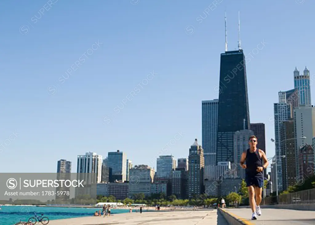 Man jogging on lakefront path along Oak Street Beach, Chicago, Illinois, USA
