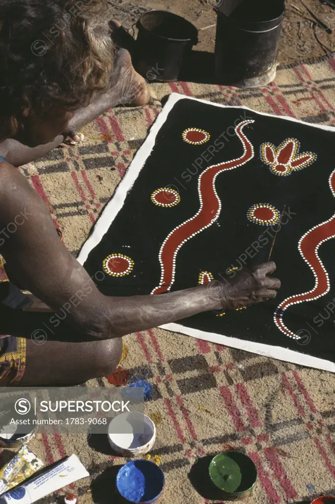 Member of Walpari tribe painting on cloth, close-up, Central Australia