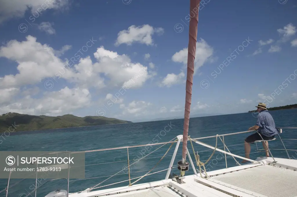 View from Catamaran of man looking at land, Queensland, Australia.
