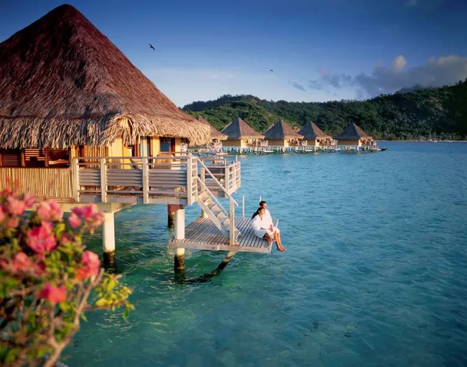Couple relaxing at an overwater bungalow; Bora Bora