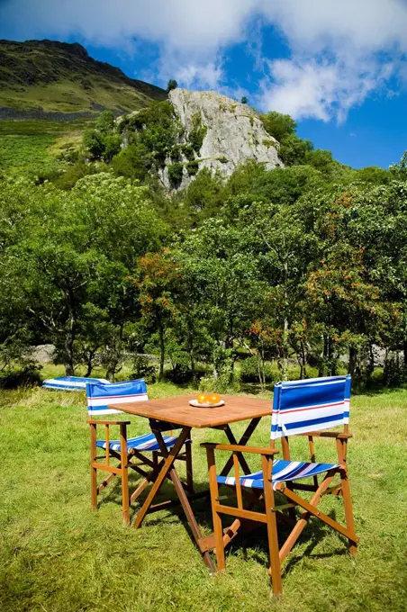 Table and chairs laid out at Llyn Gwynant Campsite; Nant Ggwynant, Snowdonia National Park, North Wales, Wales, UK