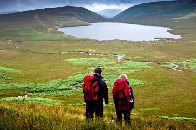 Hikers with Burnmoor Tarn; Western Lake District, Cumbria, England, UK