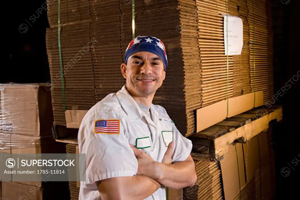 Worker standing in storage warehouse next to cardboard boxes