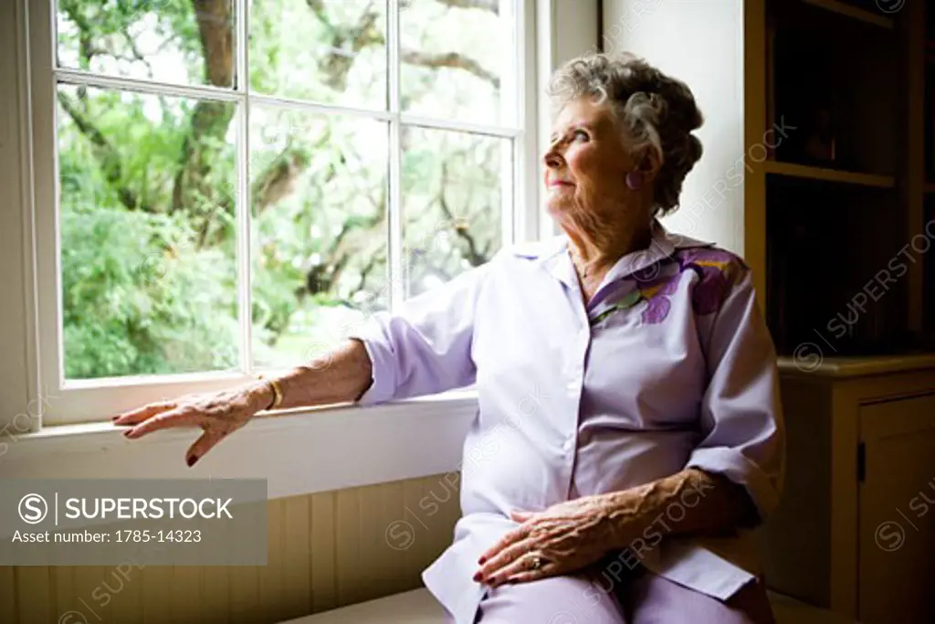 Elderly woman sitting by window