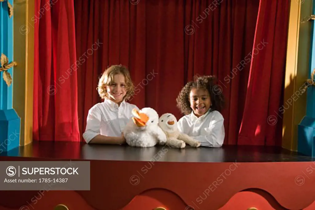 Portrait of school kids performing with animal puppets
