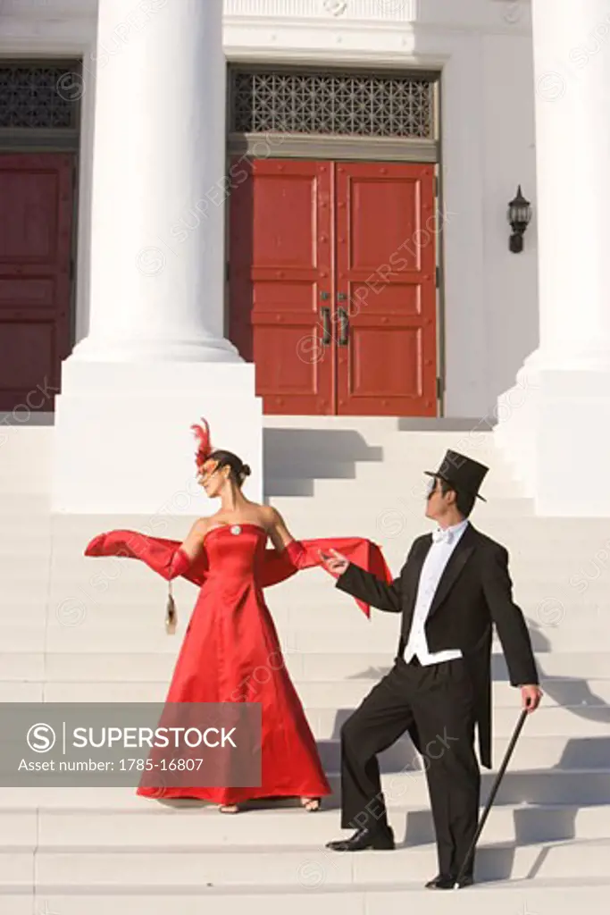 Couple in masquerade costumes standing outside theater
