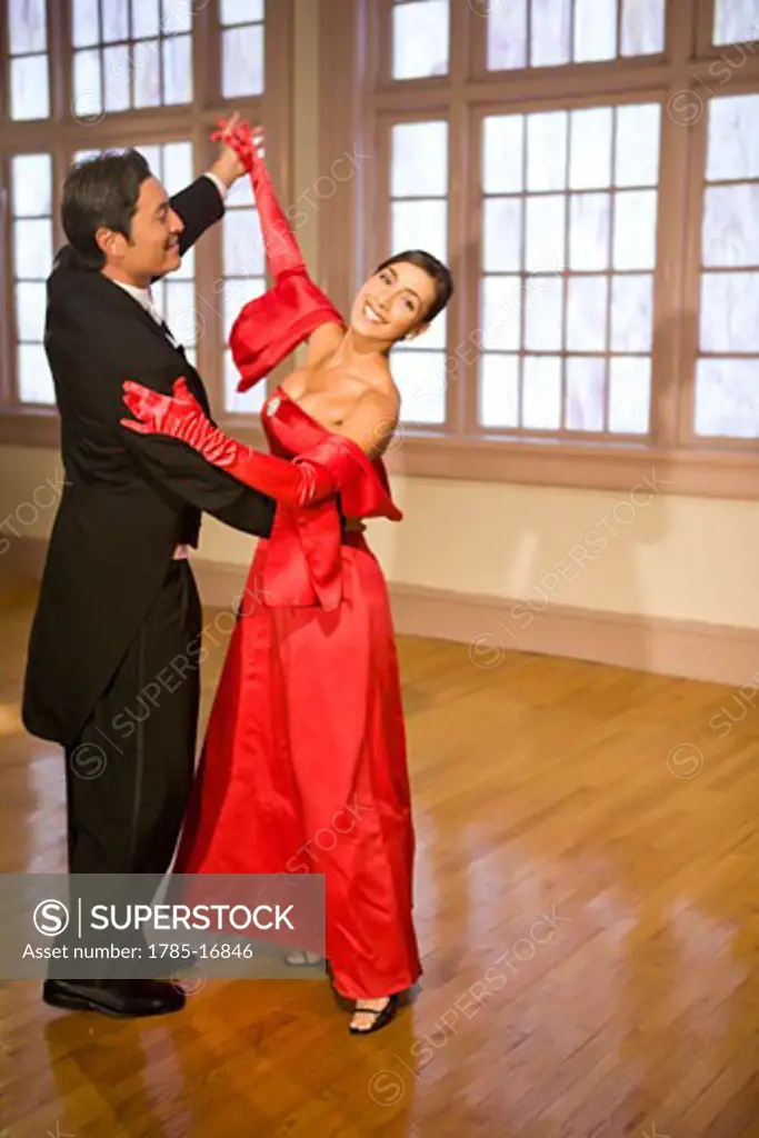 Elegant multi-racial couple ballroom dancing