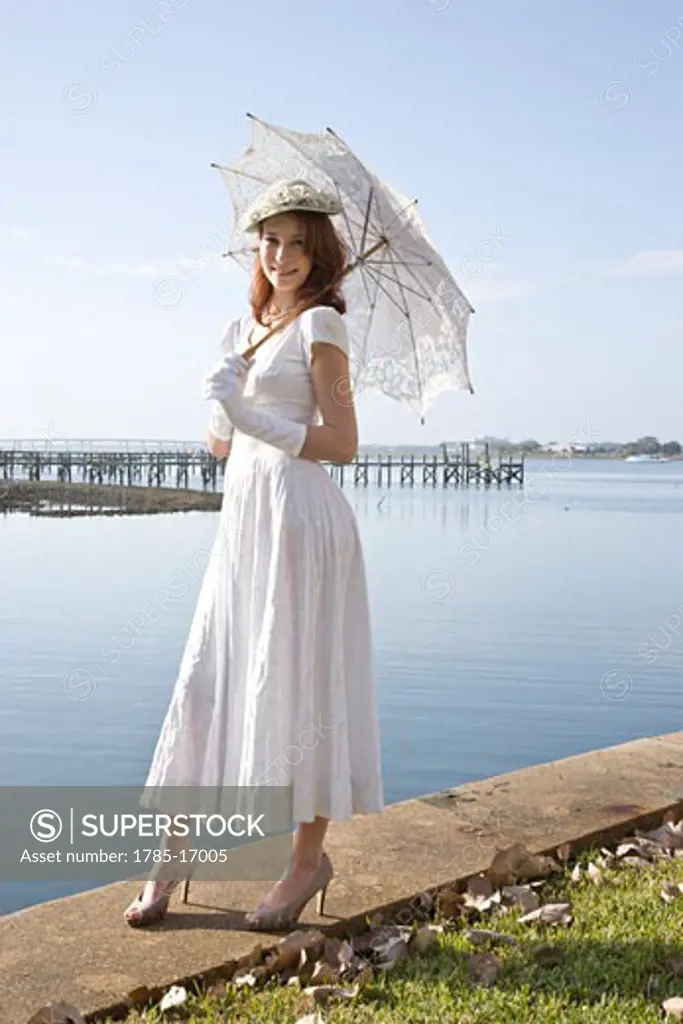 Elegant lady in white dress holding parasol