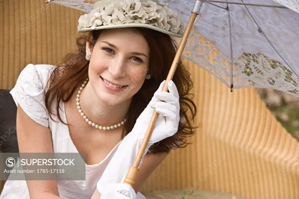 High angle view of elegant lady in white dress holding parasol