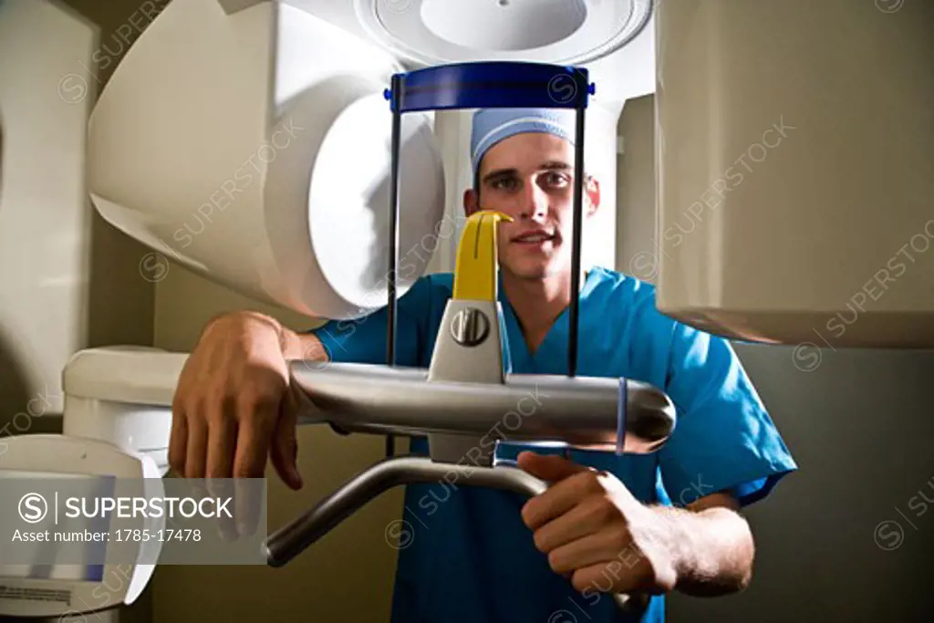 Healthcare worker standing by dental x-ray machine
