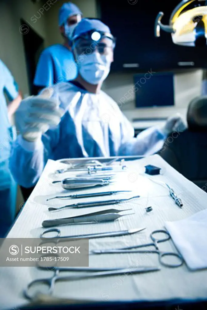 Close-up of tray of dental instruments, dentist in background
