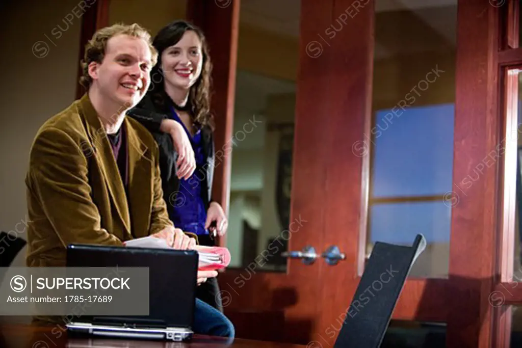 Casual businesspeople relaxing and laughing in office