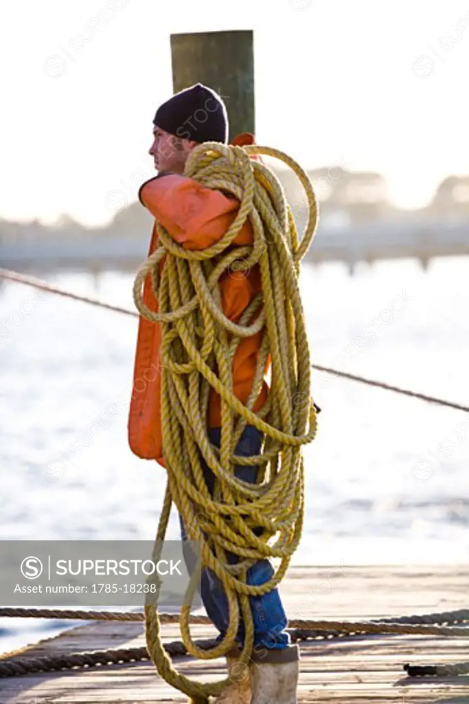 Portrait of fisherman on pier holding rope