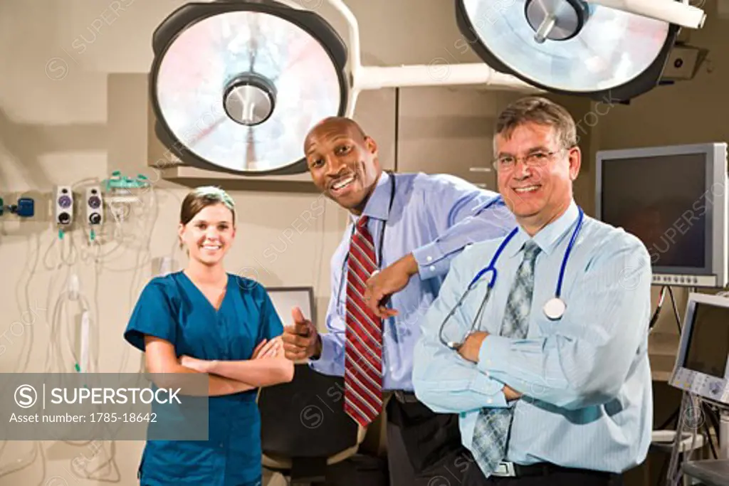 Multi-ethnic doctors and nurse in hospital room with surgical lights
