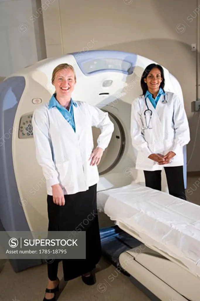 Healthcare workers standing next to CAT scan machine