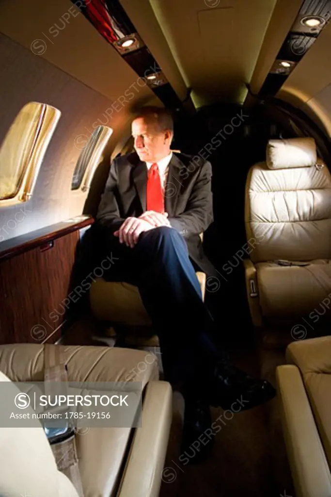 Middle-aged businessman sitting in small private jet plane