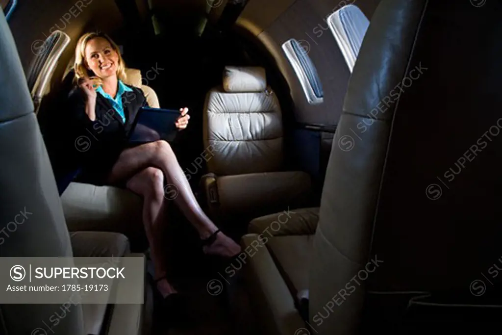 Businesswoman sitting in small private jet plane