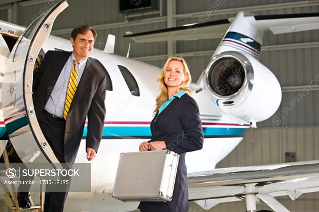 Business executives standing at doorway of corporate jet