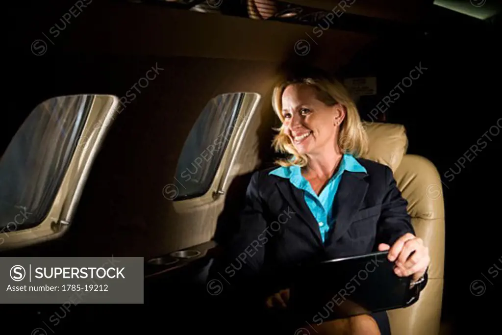 Businesswoman traveling in corporate jet