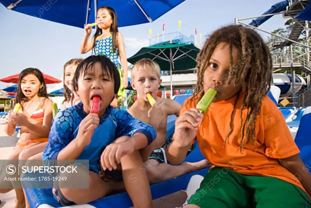 Multi-ethnic group of children eating popsicles
