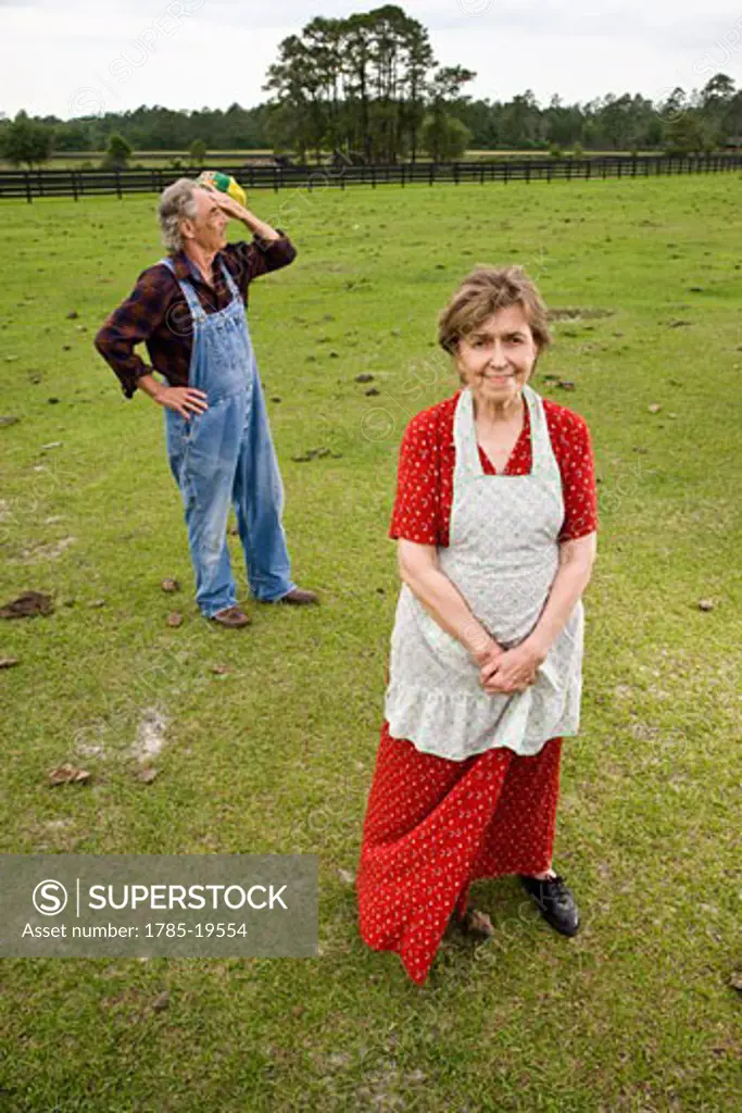 Senior couple standing in green pasture