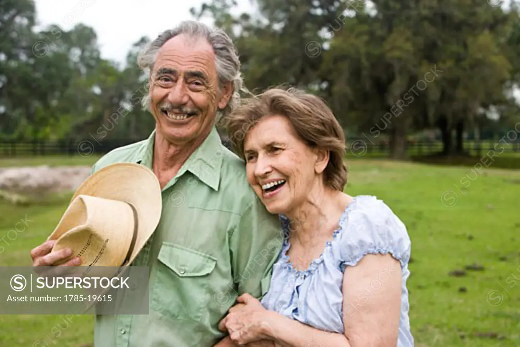 Portrait of senior couple standing in pasture