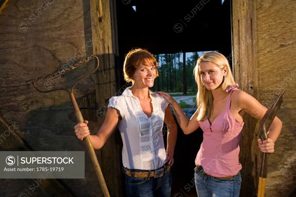 Mother and teenage daughter standing in front of stable